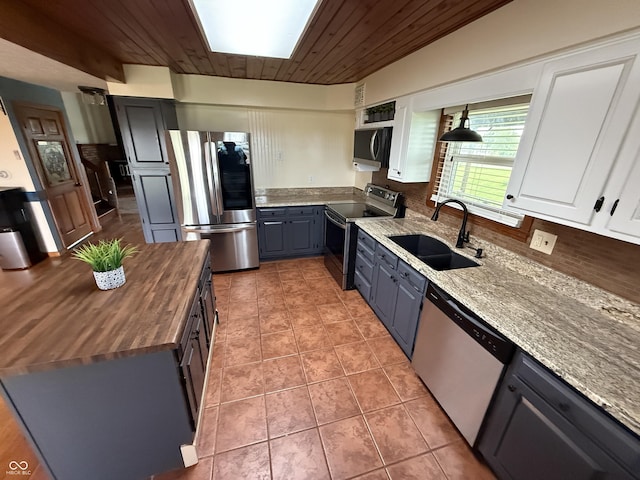 7140 N Michigan Rd, Fairland, IN 46126 - kitchen with appliances with stainless steel finishes, wood counters, a sink, decorative backsplash, and light tile patterned floors