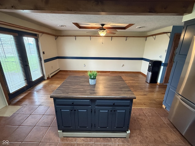7140 N Michigan Rd, Fairland, IN 46126 - kitchen with freestanding refrigerator, blue cabinets, a textured ceiling, a baseboard radiator, and ceiling fan