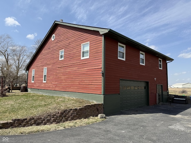 7140 N Michigan Rd, Fairland, IN 46126 - view of home's exterior featuring asphalt driveway, an attached garage, and a lawn