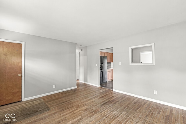 empty room featuring baseboards and wood finished floors