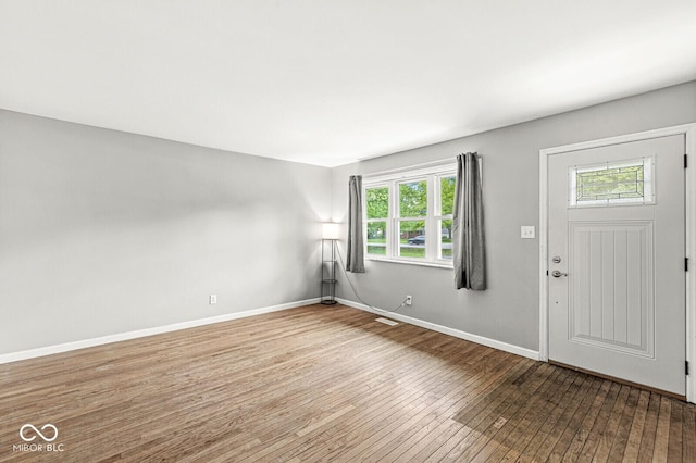 foyer featuring visible vents, baseboards, and hardwood / wood-style floors