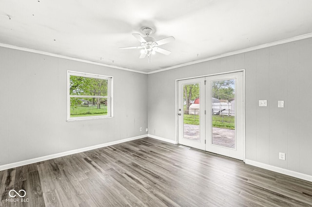 unfurnished room featuring ornamental molding, wood finished floors, and a healthy amount of sunlight