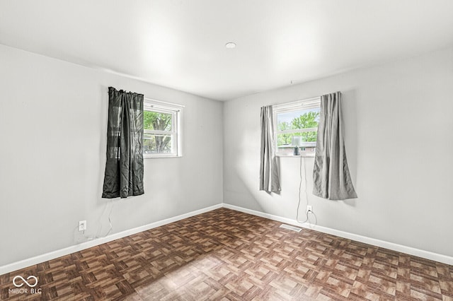 empty room featuring baseboards and visible vents