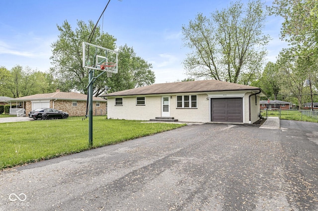 ranch-style house featuring a front yard, aphalt driveway, an attached garage, and fence