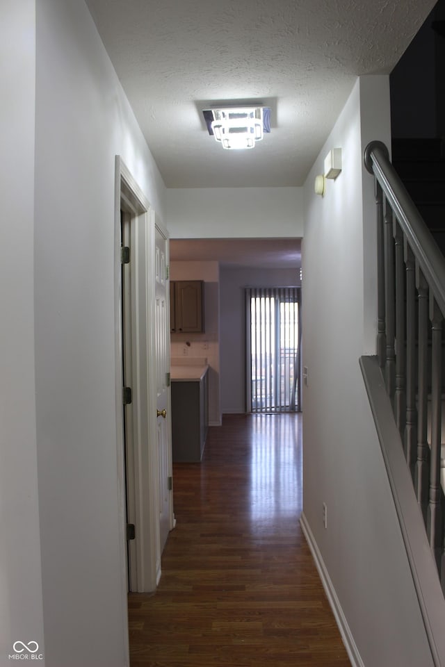 8551 Walden Trace Dr, Indianapolis, IN 46278 - hallway with dark wood-style floors, stairway, baseboards, and a textured ceiling