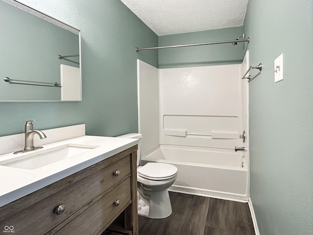 625 Streamside Dr, Greenfield, IN 46140 - bathroom featuring wood finished floors, a textured ceiling, toilet, vanity, and bathtub / shower combination