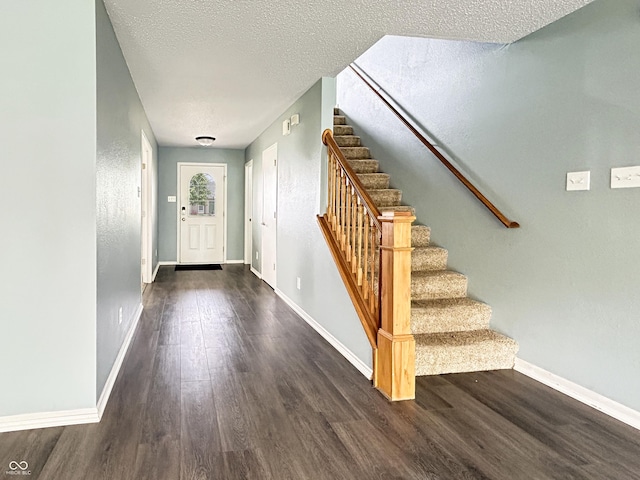 625 Streamside Dr, Greenfield, IN 46140 - entrance foyer featuring wood finished floors, baseboards, a textured ceiling, and stairs