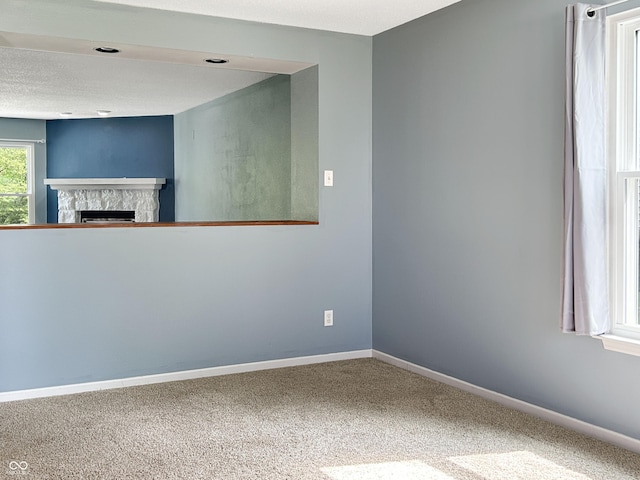 625 Streamside Dr, Greenfield, IN 46140 - unfurnished room with baseboards, a stone fireplace, and carpet