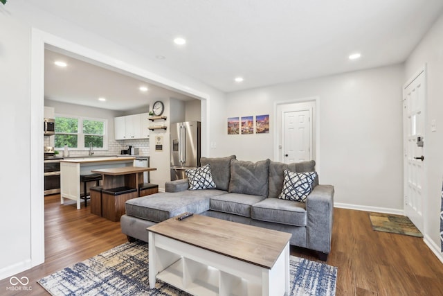 living area with baseboards, recessed lighting, and dark wood-type flooring