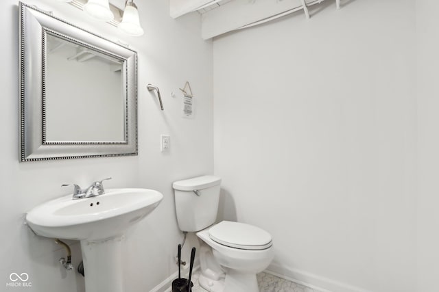 half bathroom featuring toilet and baseboards
