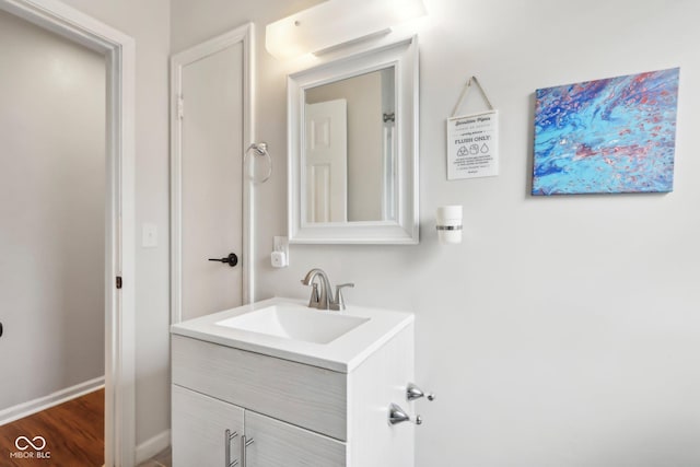 bathroom featuring baseboards, vanity, and wood finished floors