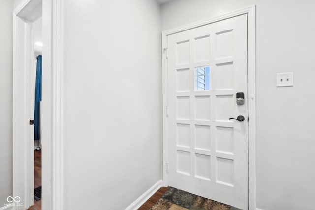 doorway to outside with baseboards and dark wood-style floors