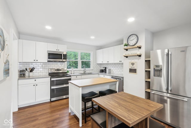 kitchen with backsplash, stainless steel appliances, open shelves, and a sink