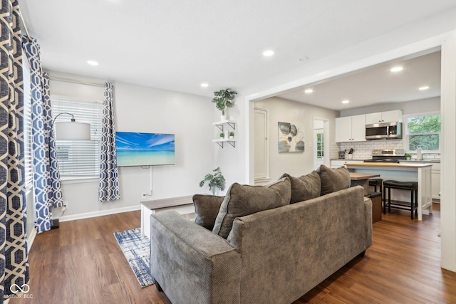 living room featuring baseboards, recessed lighting, and dark wood-style floors
