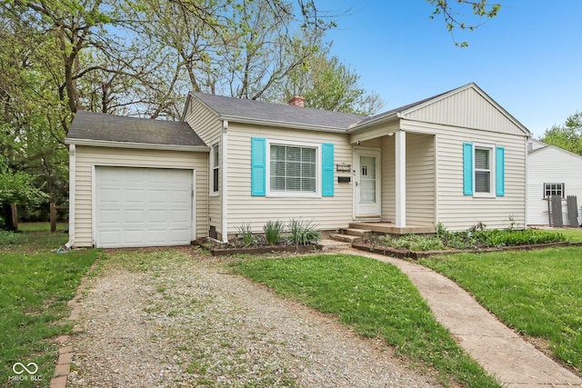 view of front facade with a front yard, an attached garage, a chimney, and driveway