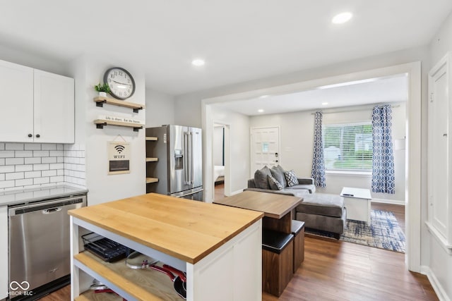 kitchen with open shelves, white cabinetry, stainless steel appliances, and butcher block counters