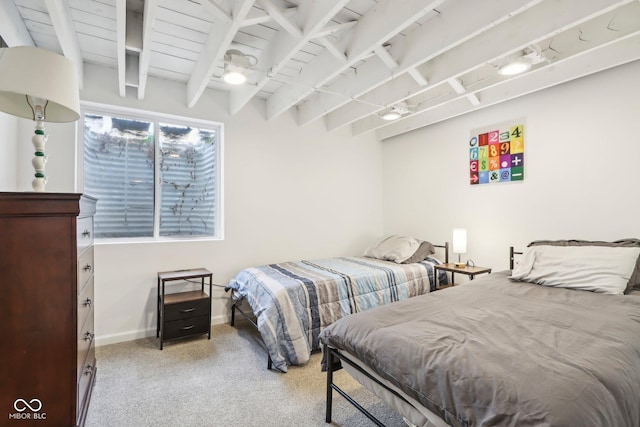 bedroom featuring light carpet, baseboards, and beamed ceiling
