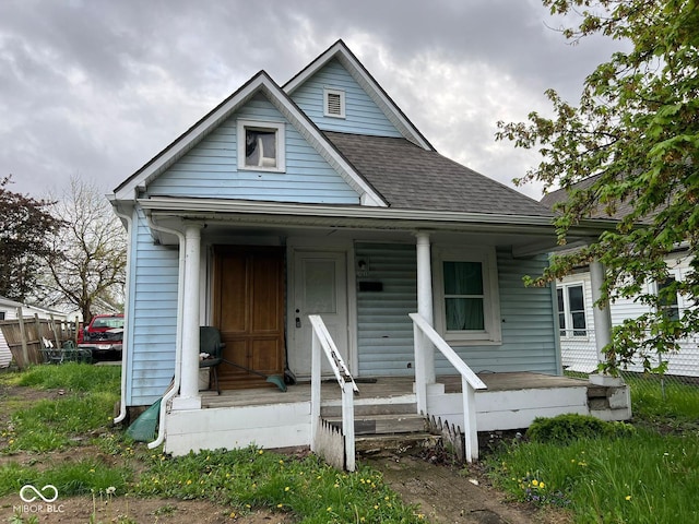 view of front of home featuring covered porch and a shingled roof