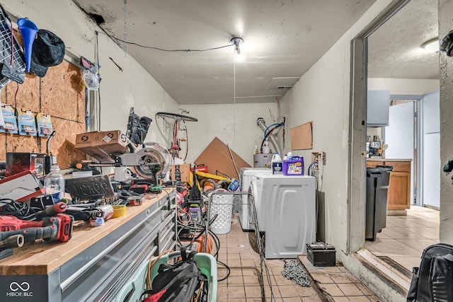 below grade area with light tile patterned floors, a workshop area, and washing machine and dryer