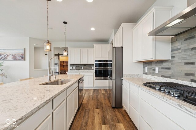 kitchen featuring a sink, wall chimney exhaust hood, white cabinetry, decorative backsplash, and dark wood-style floors