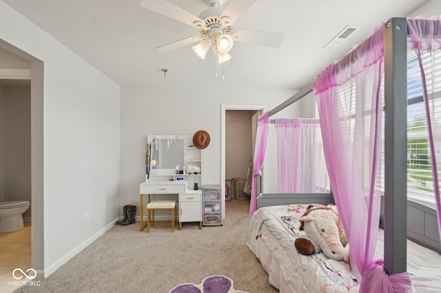 carpeted bedroom featuring connected bathroom, visible vents, baseboards, and a ceiling fan