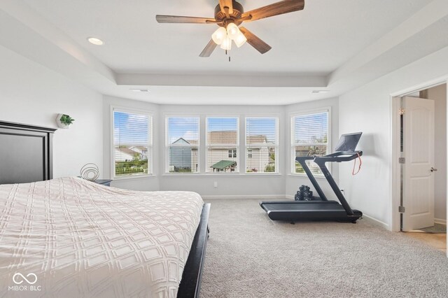 bedroom with a tray ceiling, recessed lighting, baseboards, ceiling fan, and carpet floors