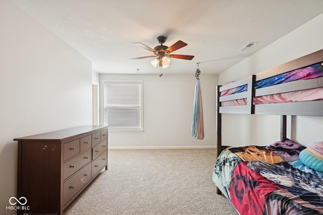 bedroom featuring light colored carpet, visible vents, baseboards, and ceiling fan