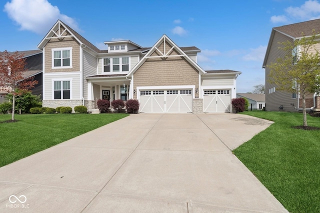 craftsman-style home featuring concrete driveway, stone siding, a front yard, and a garage