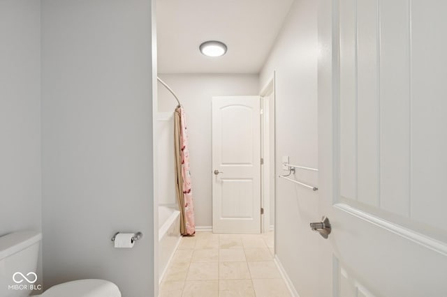 bathroom featuring toilet, tile patterned floors, and shower / bath combination with curtain