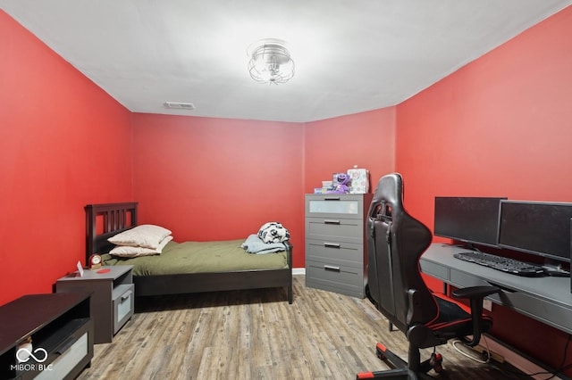 bedroom featuring visible vents and wood finished floors