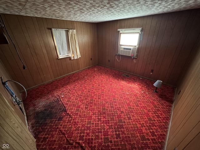 empty room with cooling unit, wooden walls, and baseboards