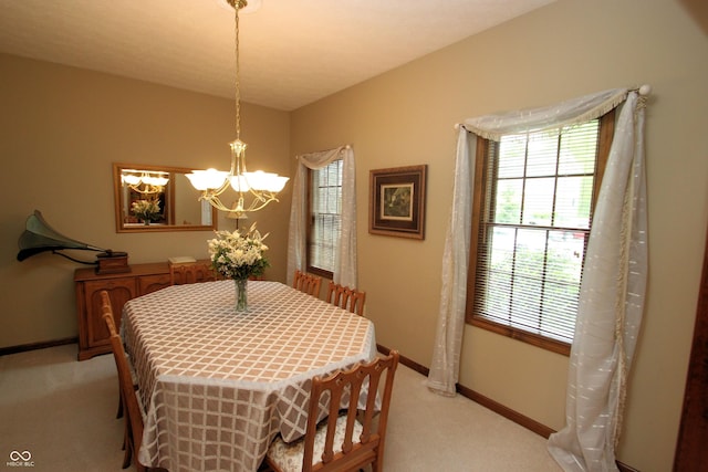 dining area with baseboards, a wealth of natural light, a chandelier, and light colored carpet