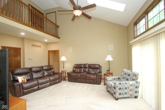 carpeted living area with ceiling fan, visible vents, high vaulted ceiling, and a skylight