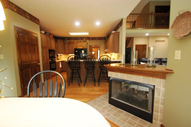 dining area featuring a multi sided fireplace, light wood-style flooring, and recessed lighting