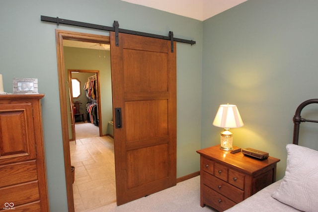 bedroom with a closet, a barn door, and a spacious closet