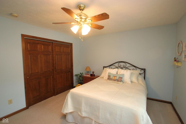 bedroom with a closet, light carpet, baseboards, and a ceiling fan