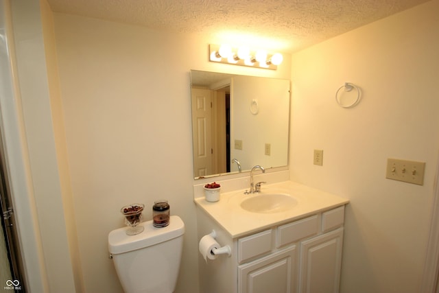 bathroom with toilet, vanity, and a textured ceiling