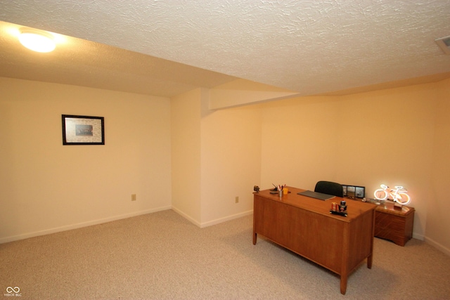 home office with baseboards, a textured ceiling, and light colored carpet