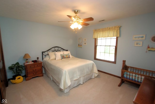 carpeted bedroom with a ceiling fan and visible vents