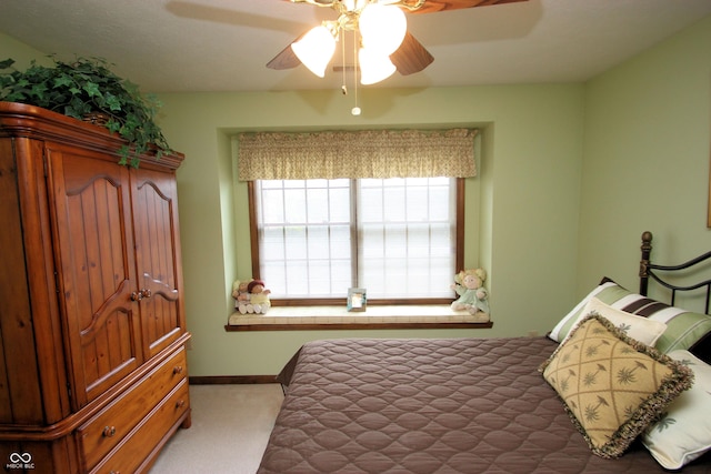 carpeted bedroom with ceiling fan and baseboards