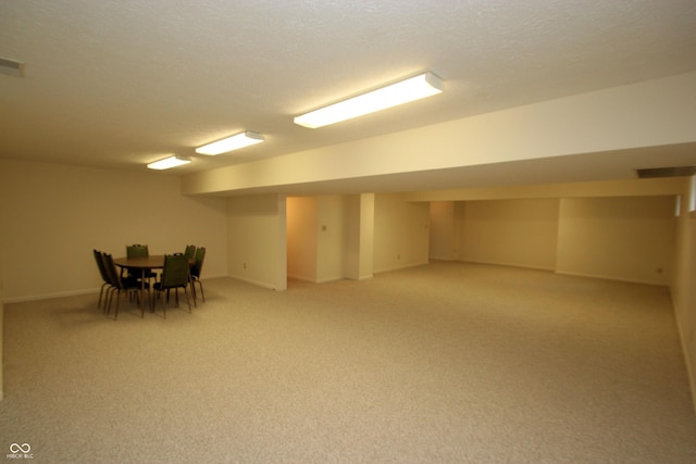 finished basement with baseboards and light carpet