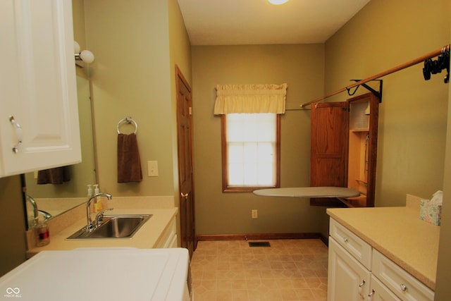 bathroom with a sink, baseboards, visible vents, and tile patterned floors