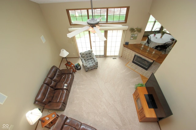 carpeted living room with a ceiling fan and a brick fireplace