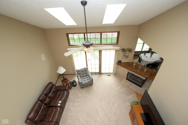 living area with carpet flooring, a fireplace with flush hearth, and a ceiling fan