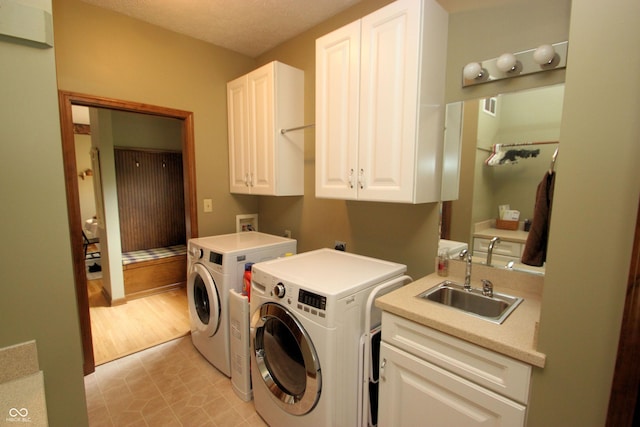 washroom with washer and dryer, a sink, visible vents, and cabinet space
