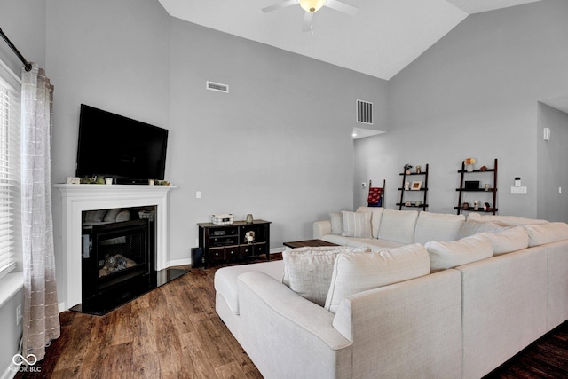 living area with ceiling fan, high vaulted ceiling, visible vents, and wood finished floors