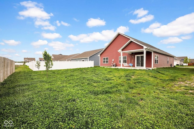 back of house with fence, a patio, and a lawn