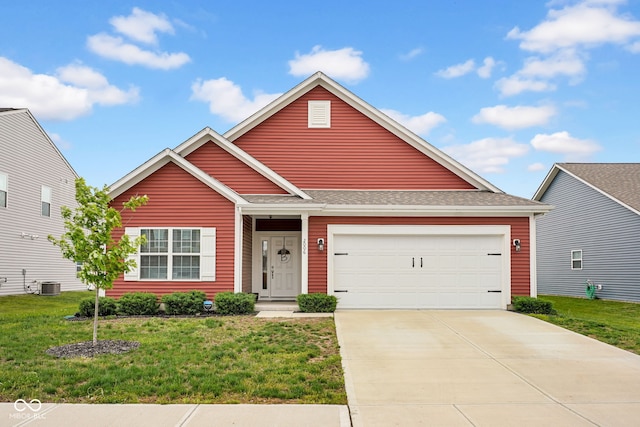 craftsman house with an attached garage, concrete driveway, a shingled roof, central AC unit, and a front yard