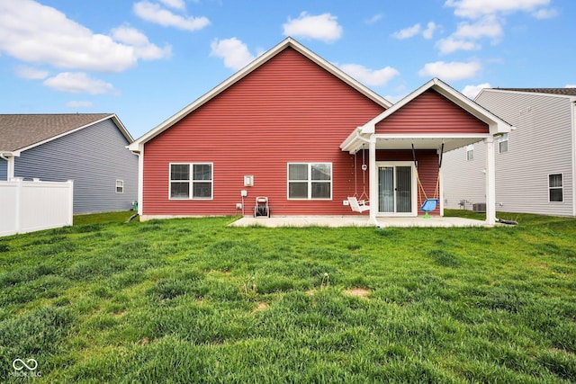 rear view of property with a lawn, a patio area, and fence