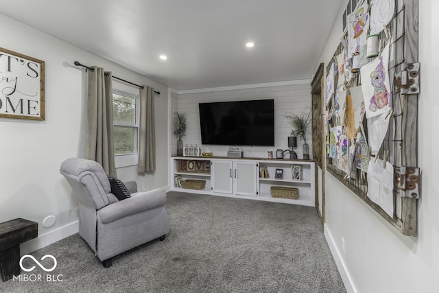 carpeted living area with wood walls, baseboards, an accent wall, and recessed lighting
